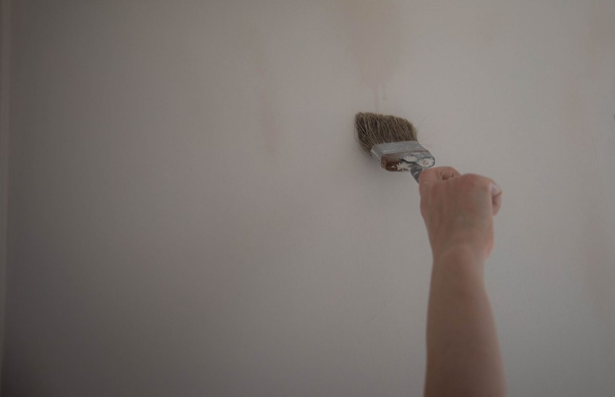 Peinture d'un mur intérieur avec pinceau et rouleau
