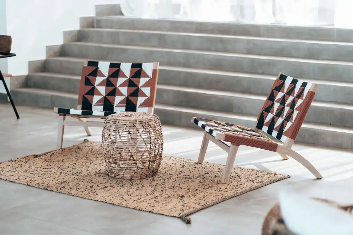Intérieur épuré avec mobilier en bois brut et tapis graphique contrastant sur sol clair