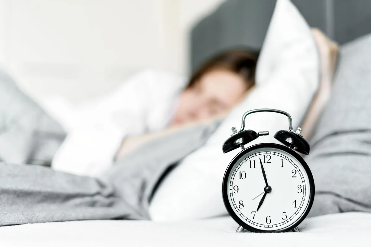 Personne mettant en place une routine matinale cohérente avec un réveil et un horaire régulier