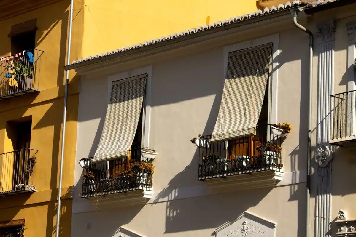 Fenêtre d'appartement exposée au sud avec stores pour réduire la chaleur estivale