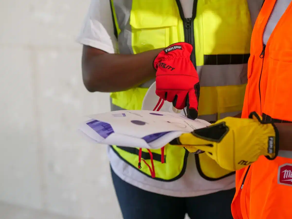 Artisans en coordination sur un chantier de rénovation, échangeant sur le planning et l'ordre d'intervention.