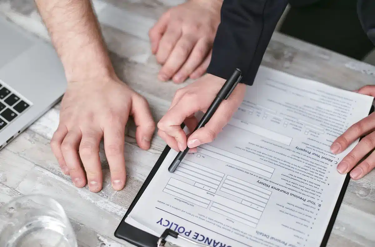 Document d'assurance habitation ouvert sur un bureau avec stylo et lunettes