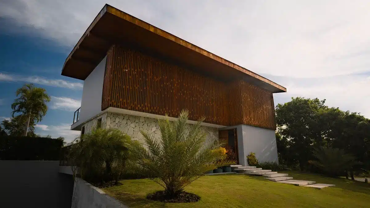 Intérieur moderniste avec bois et pierre locale créant une liaison avec le paysage tropical
