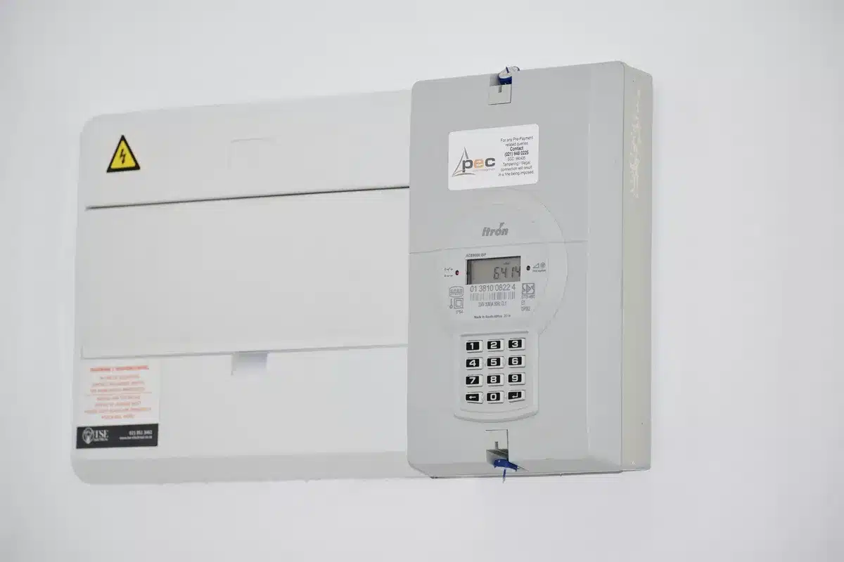Compteur électrique et panneaux solaires illustrant l'autoconsommation d'électricité