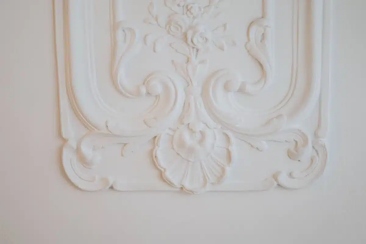 Corniche et rosace en staff, ornementations en relief de style classique.