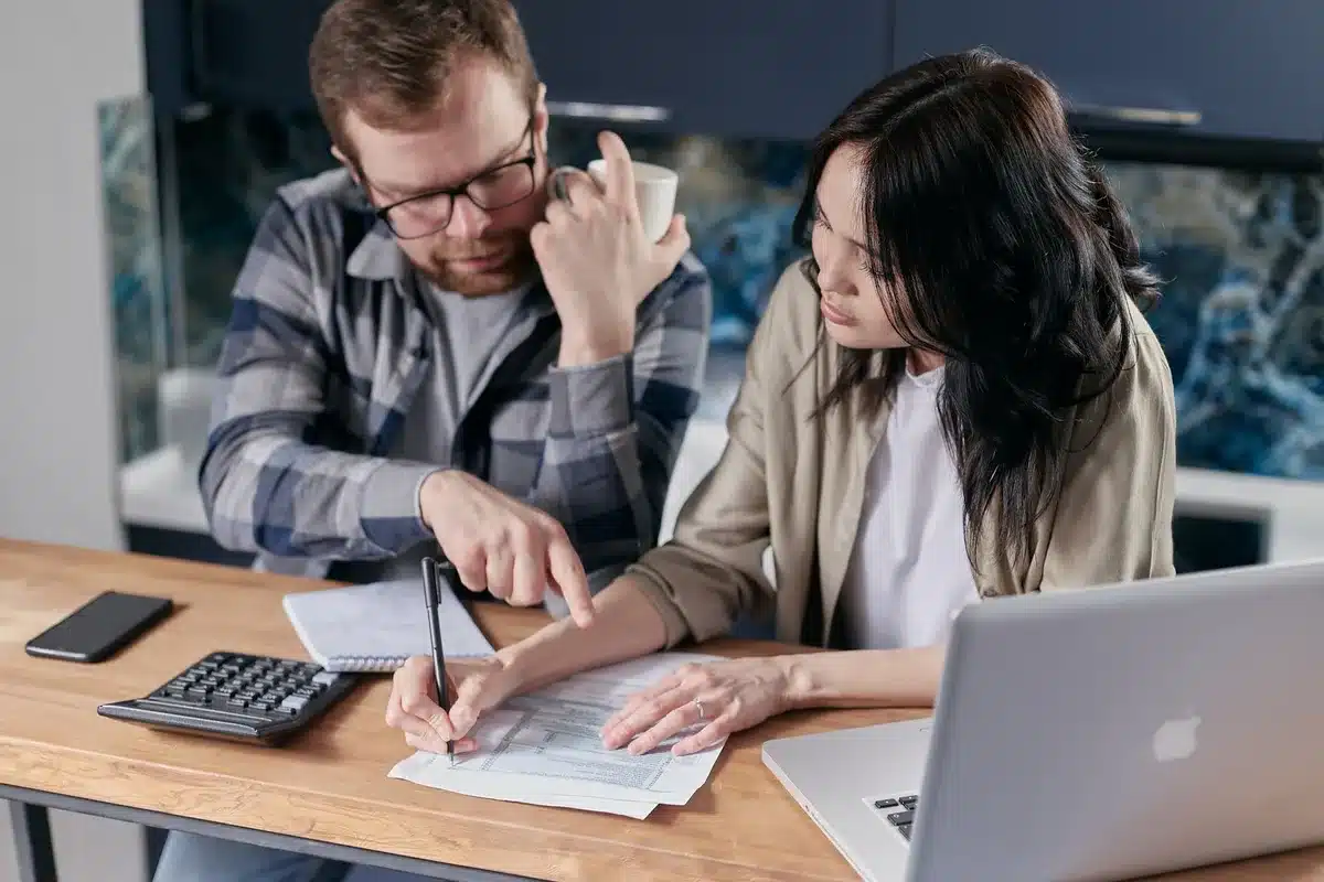 Plusieurs devis détaillés étalés pour comparaison, avec stylo et calculatrice.
