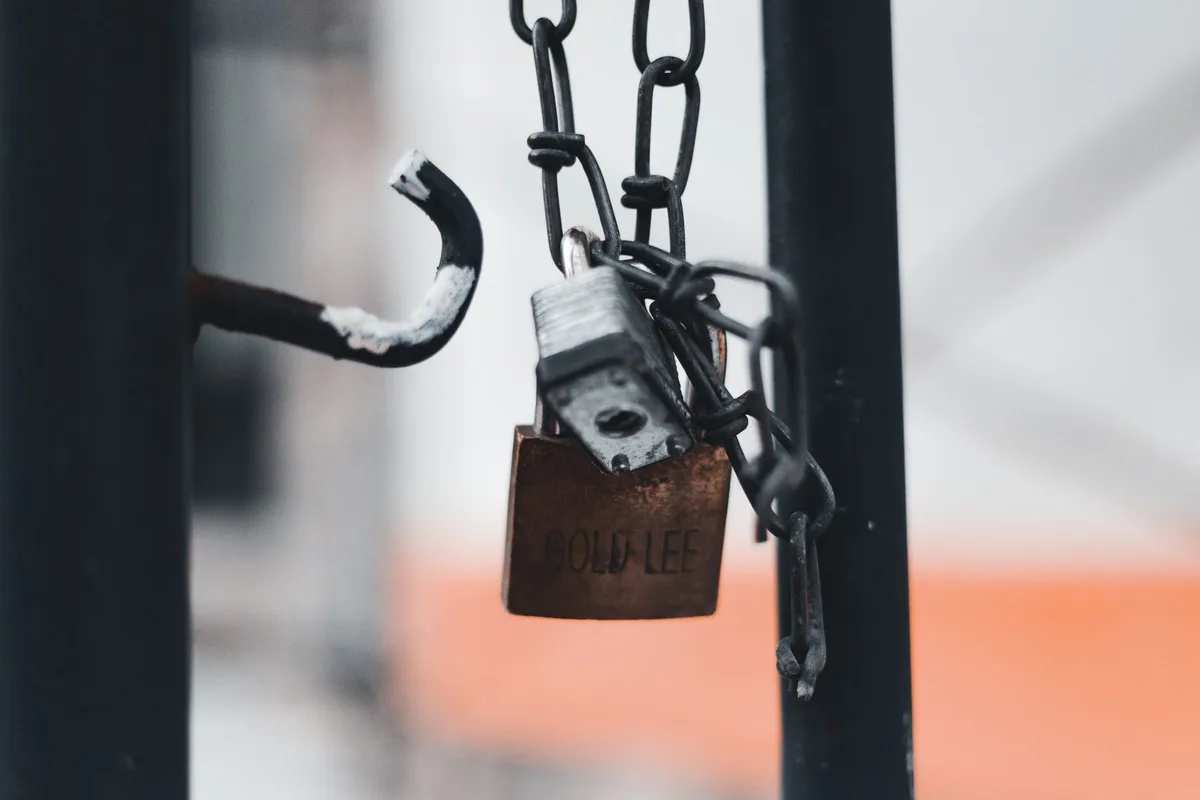 Main d'une personne verrouillant la porte d'entrée avant de partir en vacances