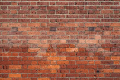 Ouvrier posant des briques avec du mortier sur un mur en construction
