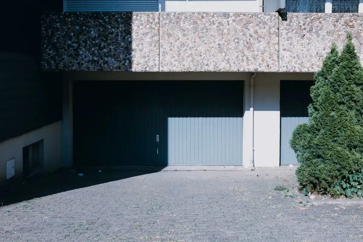 Porte de garage latérale ouverte montrant l'espace dégagé nécessaire au sol et le long du mur.