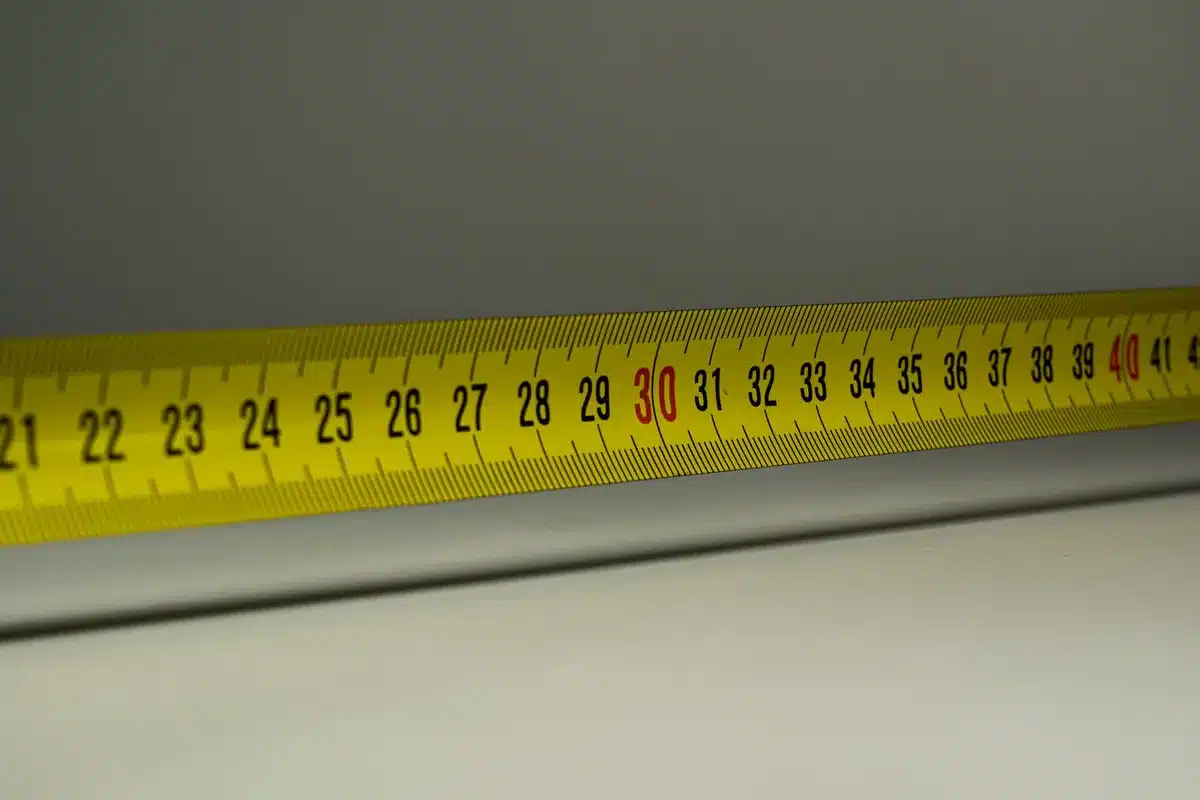 Mesure d'une dalle de béton avec un mètre ruban pour calculer le volume