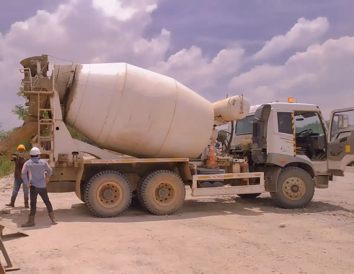 Toupie de béton prêt à l'emploi déversant le béton sur un chantier