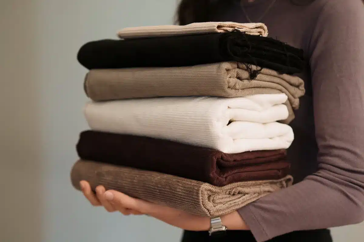 Détail de matières variées : tissu lisse, velours et maille sur des accessoires de décoration