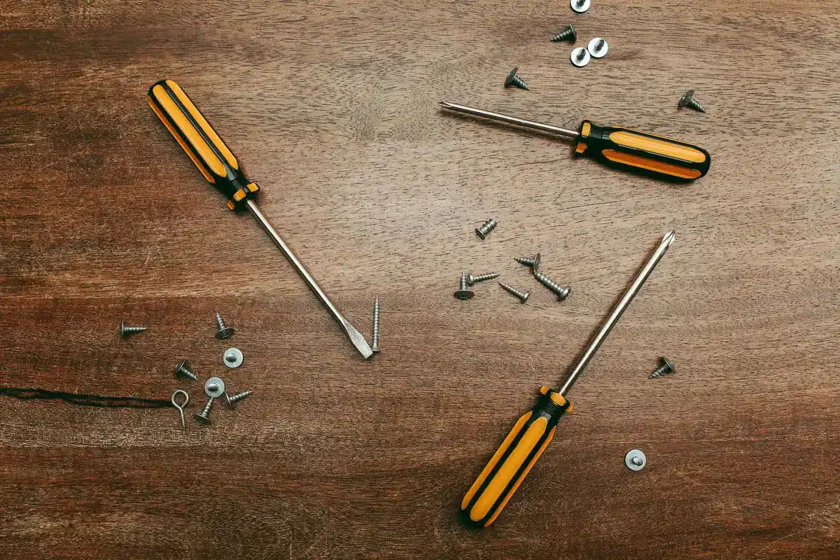 Vis enfoncée en biais dans une lame de parquet pour la refixer
