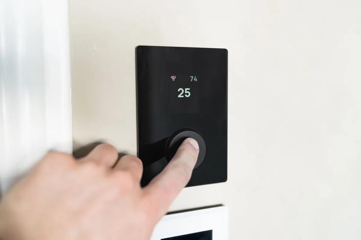 Thermostat connecté affichant la température et les paramètres de programmation