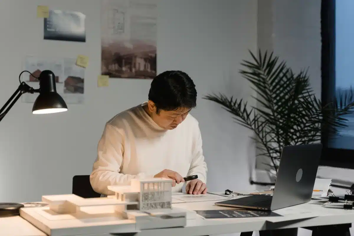 Bureau d'architecte avec plans, croquis et outils de conception étalés sur le bureau