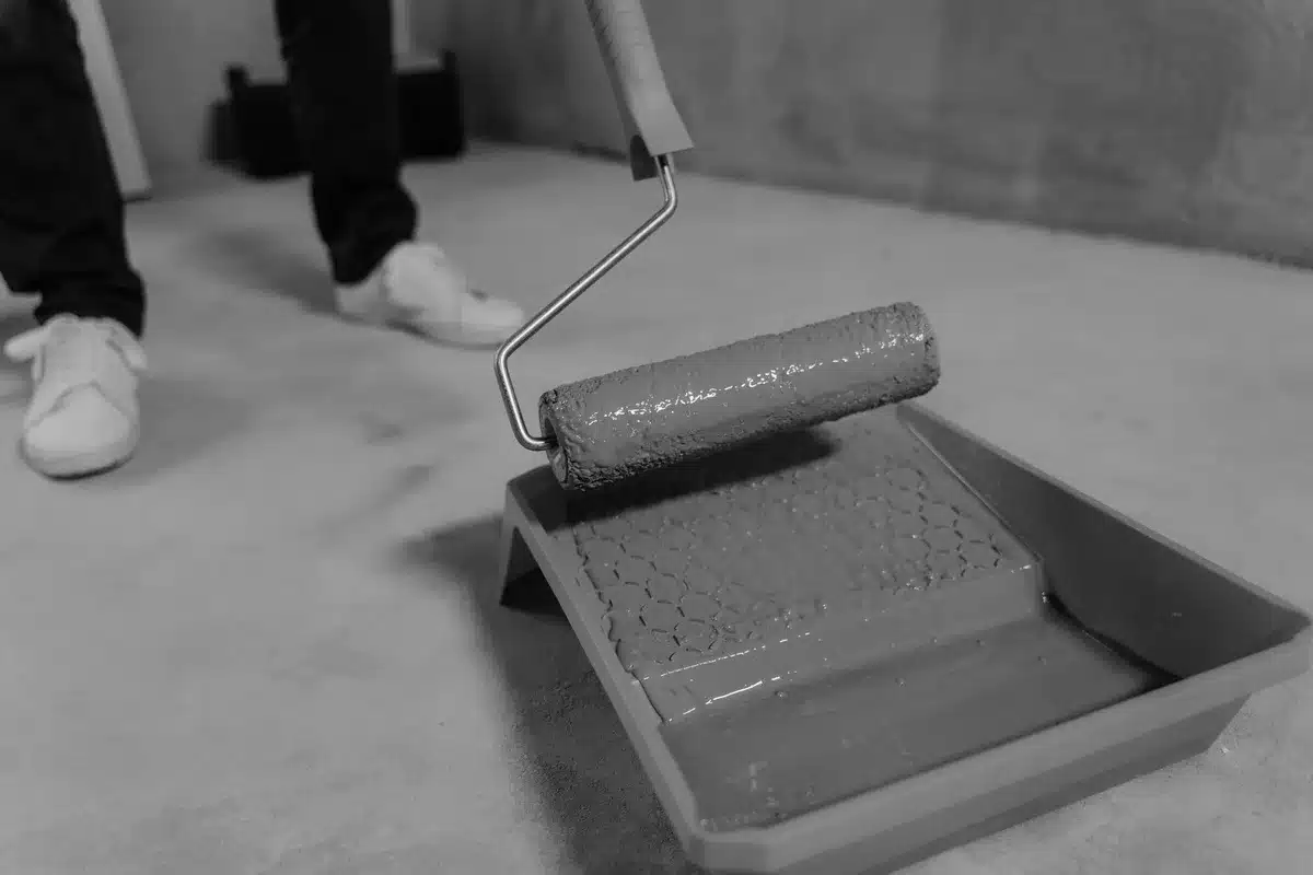 Application de peinture sur sol béton avec rouleau de peintre