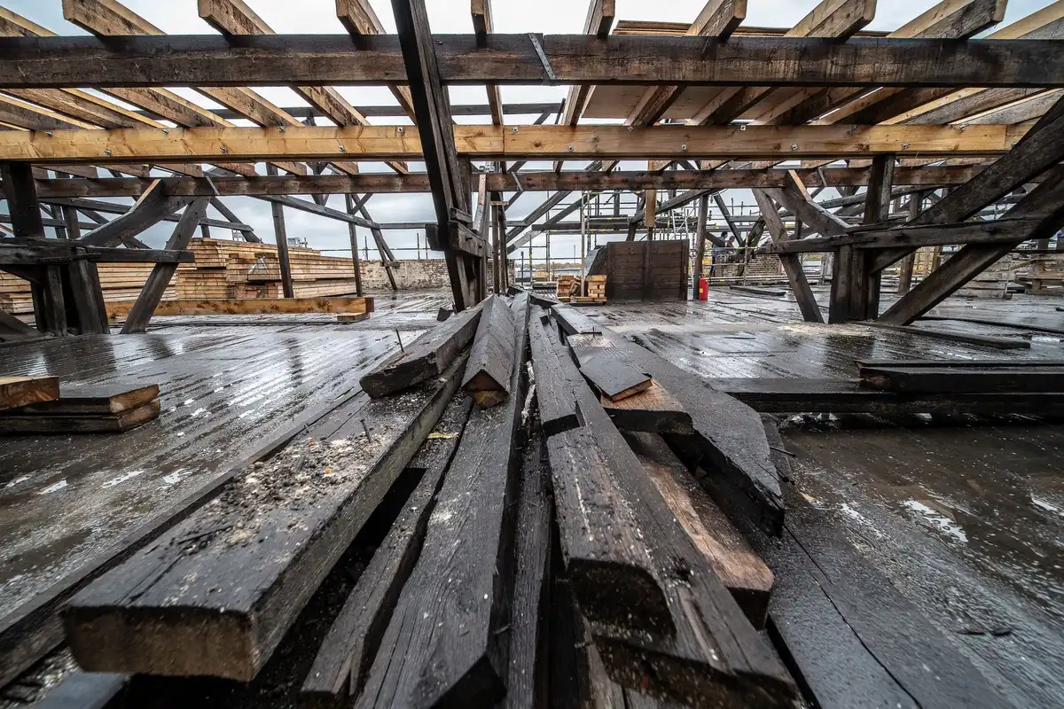 Chantier de construction d'un chalet en bois avec ossature visible et travaux de fondation