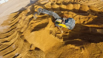 Pelle mécanique excavant la terre végétale sur un chantier de fondation