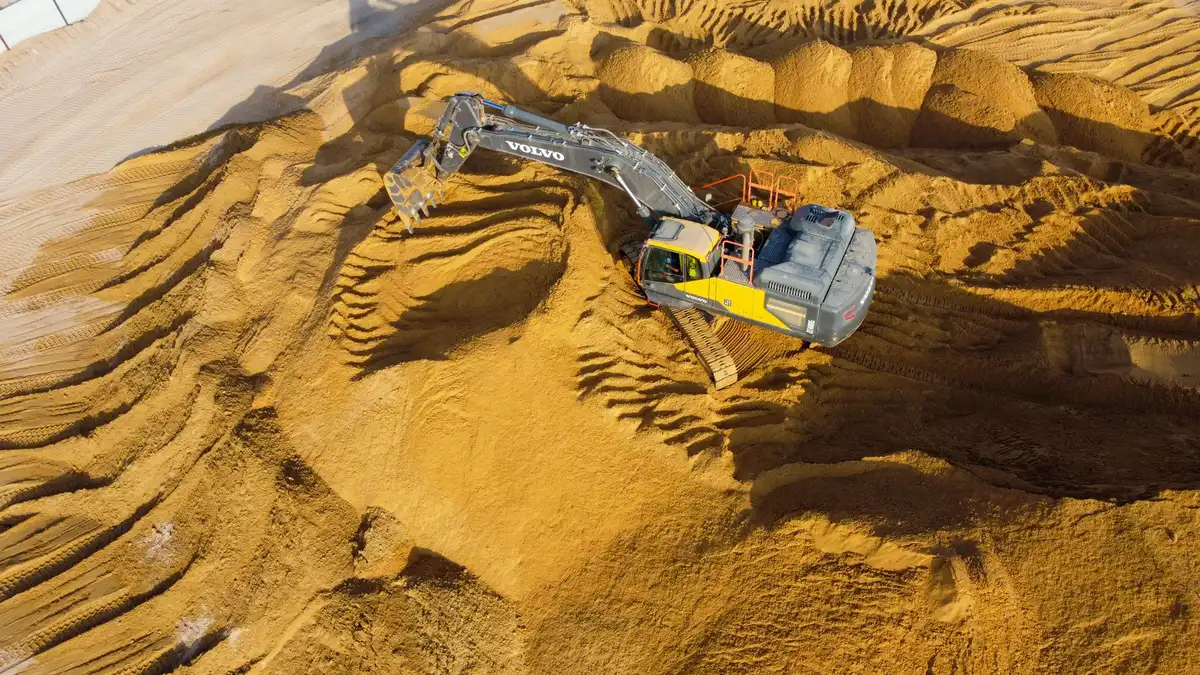 Pelle mécanique excavant la terre végétale sur un chantier de fondation