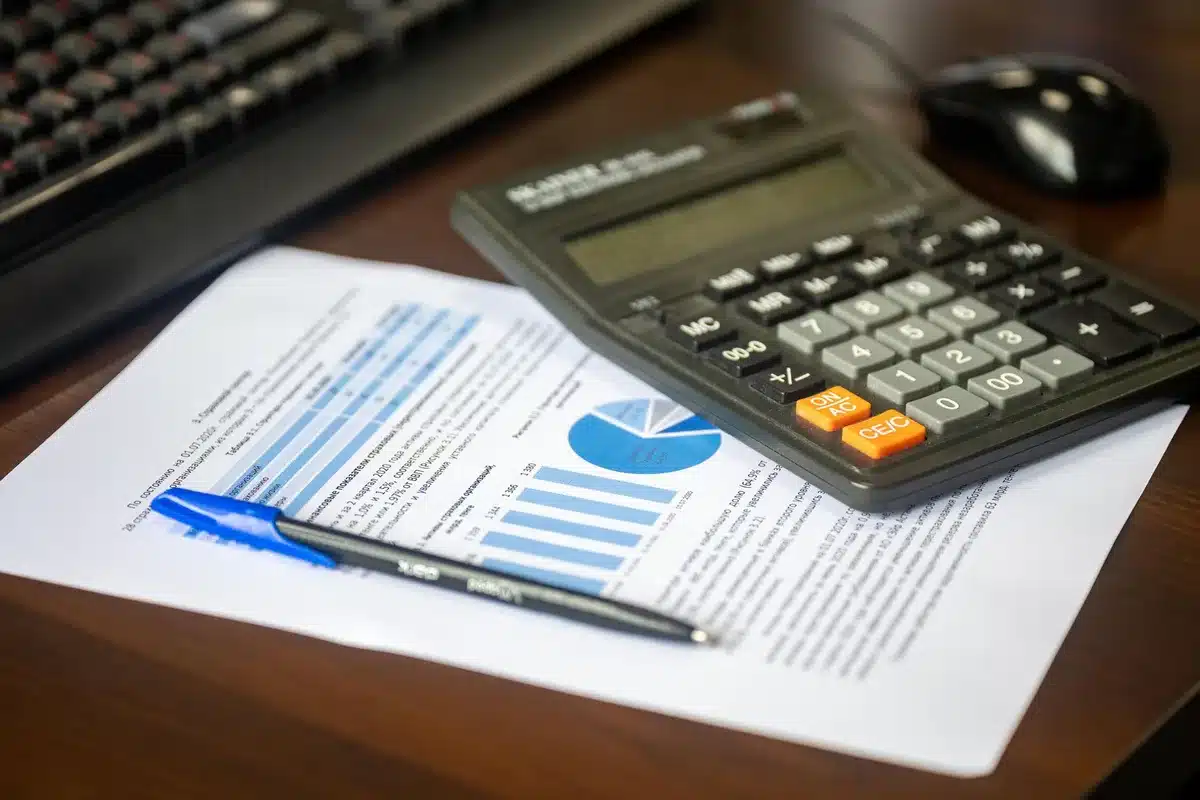 Feuille de budget, calculatrice et documents financiers pour estimer le coût d'une construction