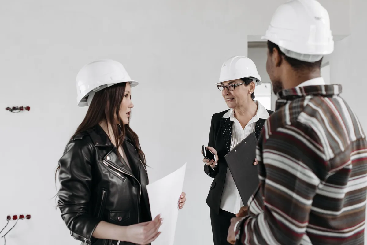 Professionnel présentant des plans et devis de construction à un couple