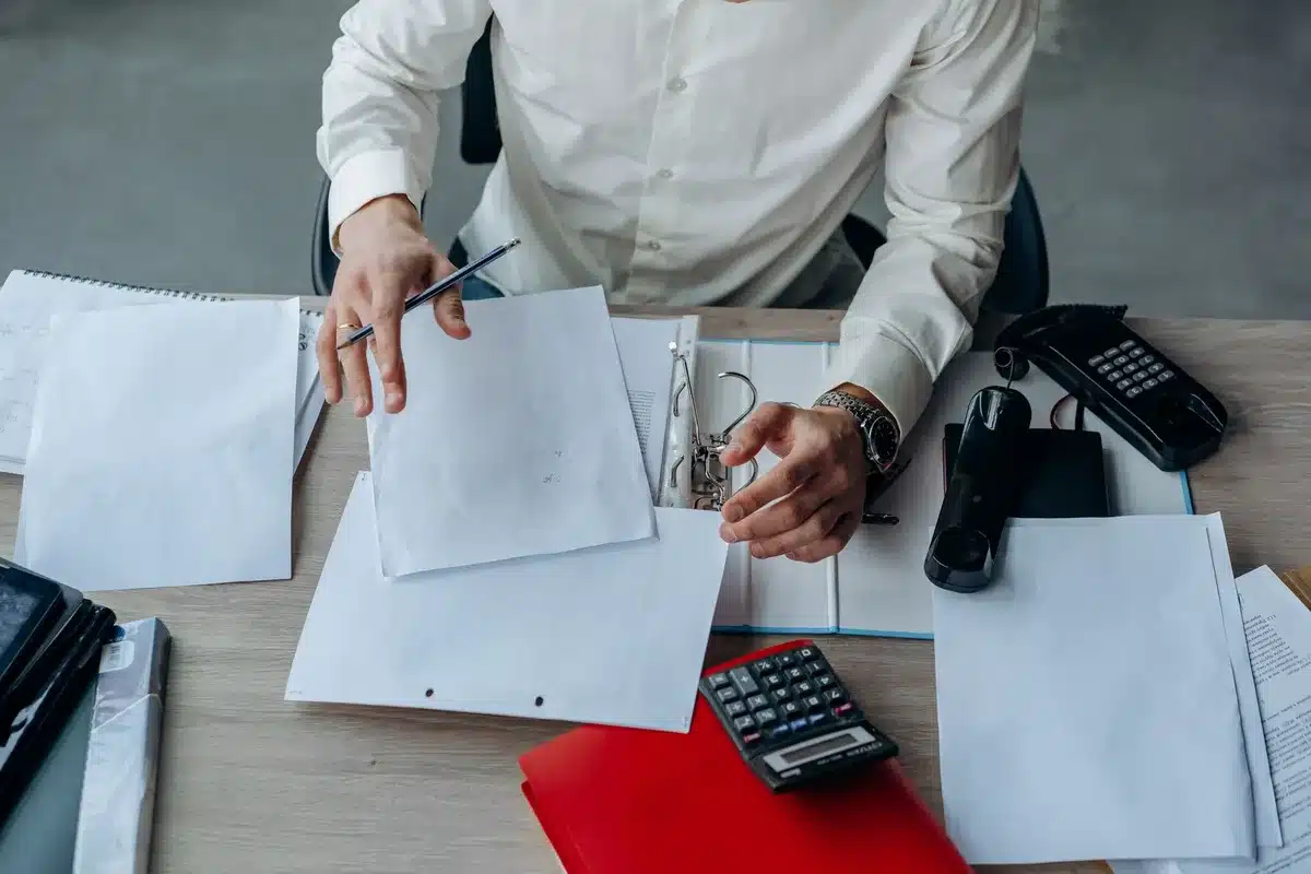 Documents de rénovation et plans d'aide financière sur un bureau ensoleillé
