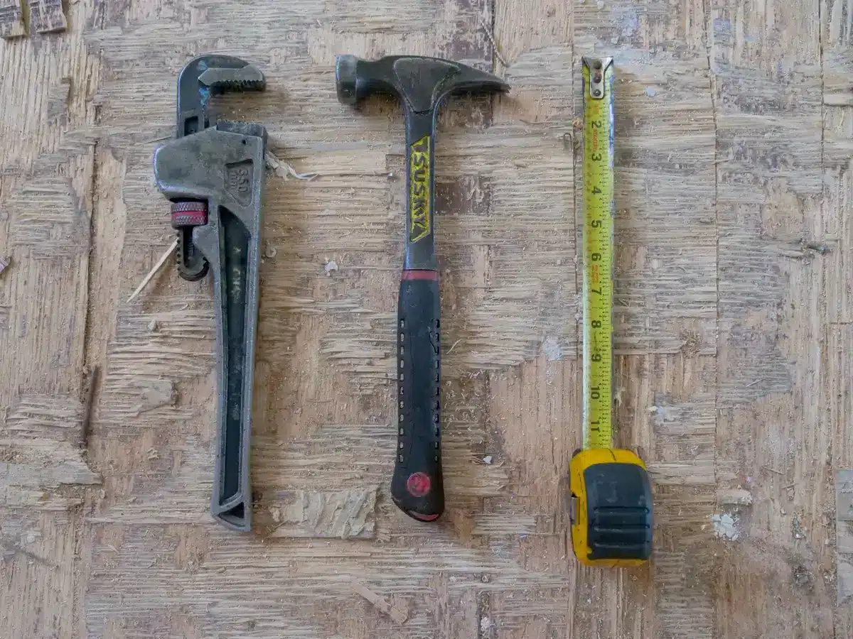 Outils essentiels pour l'installation : clé, niveau, mètre ruban et tournevis