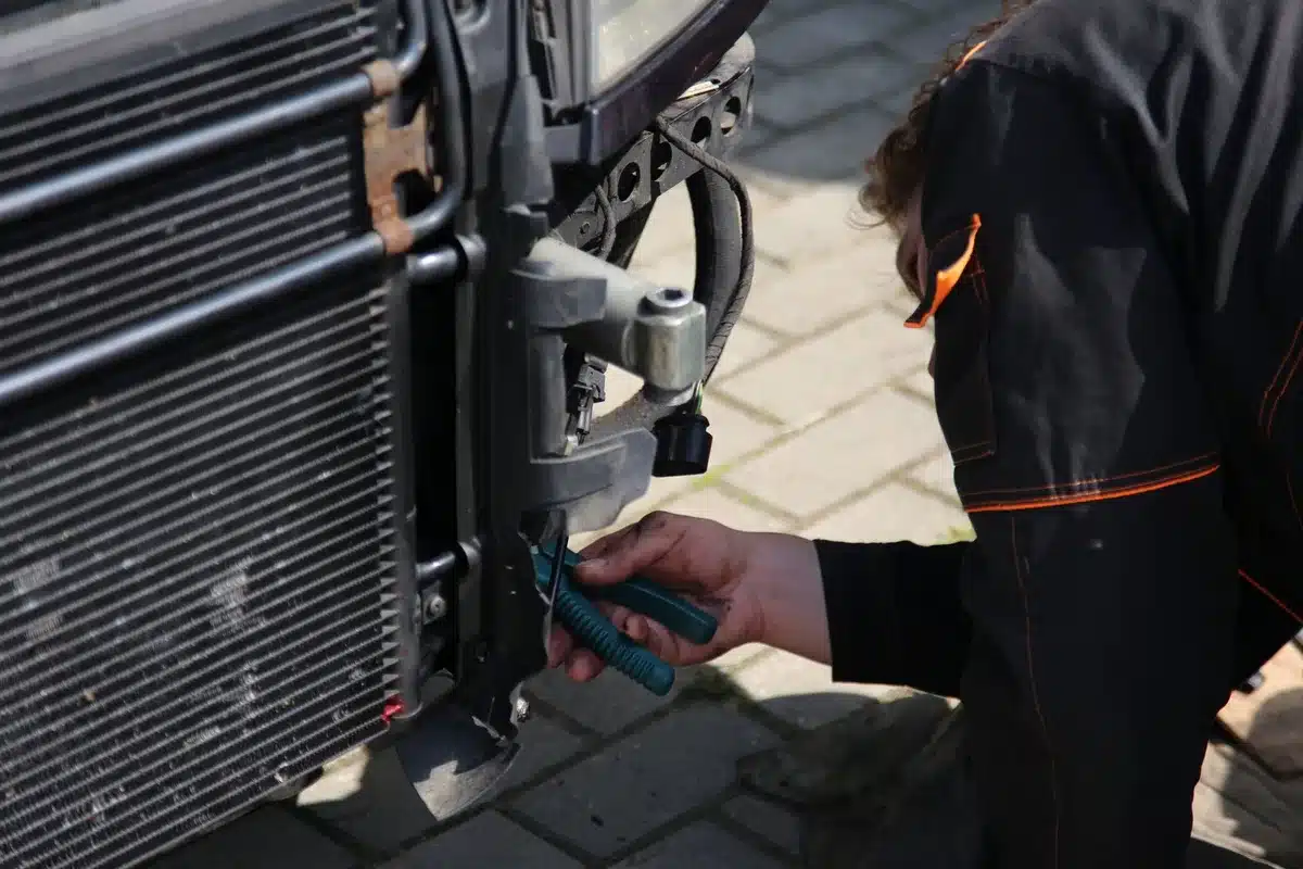 Mains d'un technicien réglant une pompe à chaleur moderne dans un espace technique résidentiel
