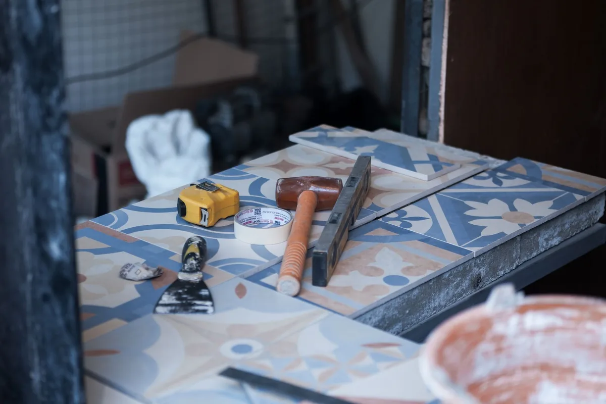 Outils de maçonnerie : niveau, truelle, maillet et seau de mortier