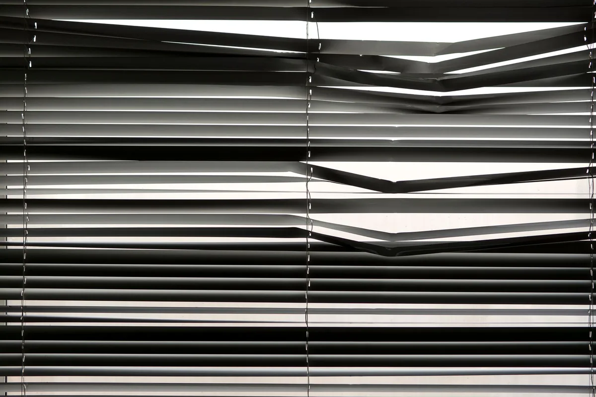Détail de la pose d'un store occultant avec rails latéraux pour éviter les fuites de lumière