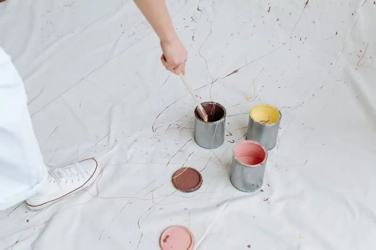 Peintre professionnel examinant des pots de peinture de différentes couleurs et finitions