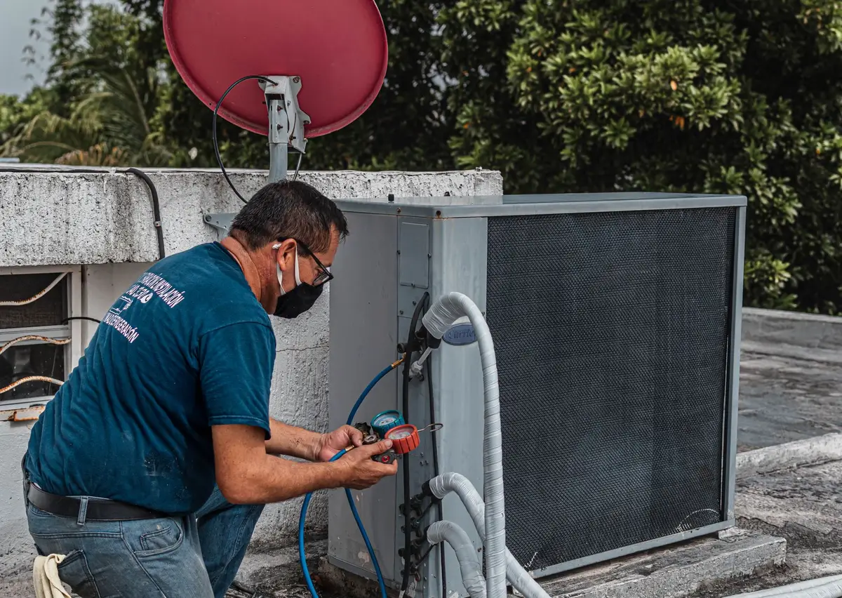 Technicien contrôlant l'étanchéité d'une climatisation réversible