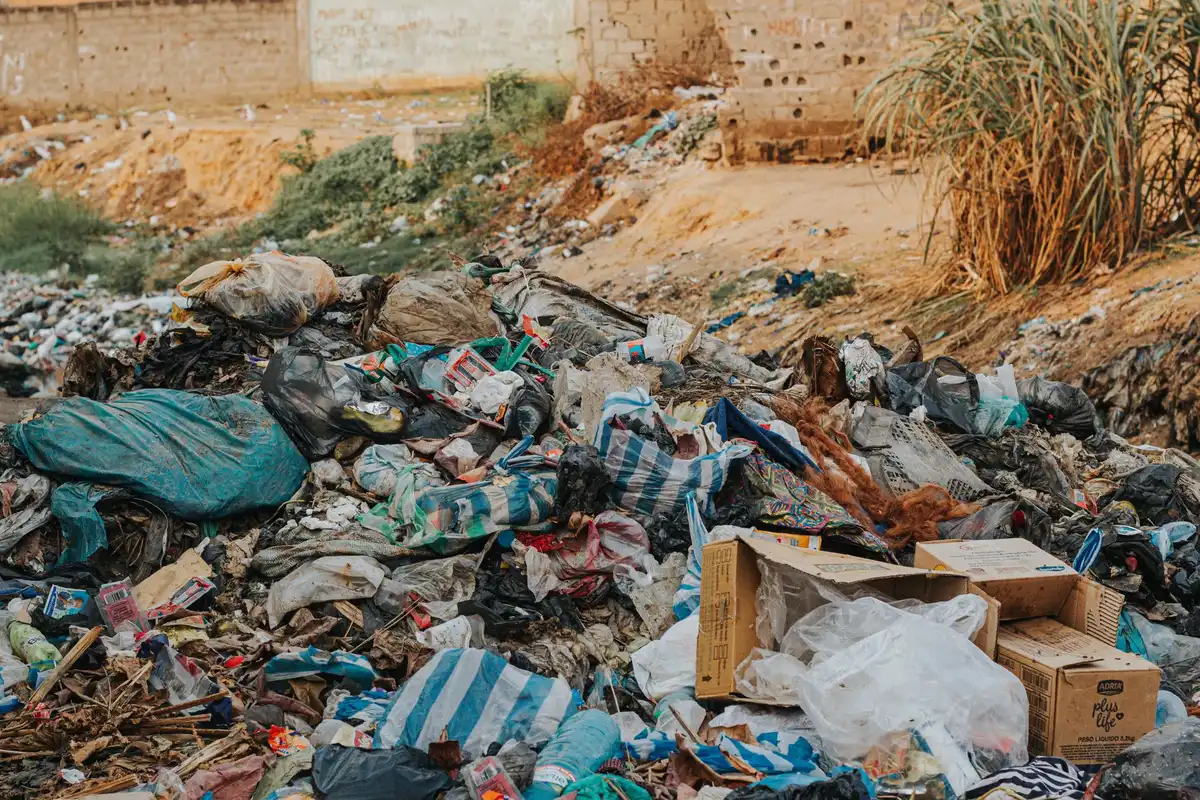 Jardin résidentiel encombré de déchets, gravats et débris entassés de manière désordonnée.