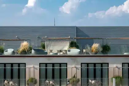 Terrasse privative d'appartement avec plantes en pots et mobilier, vue sur les immeubles voisins