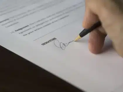 Stylo posé sur du papier vierge avec une enveloppe scellée, symbolisant la rédaction d'un testament