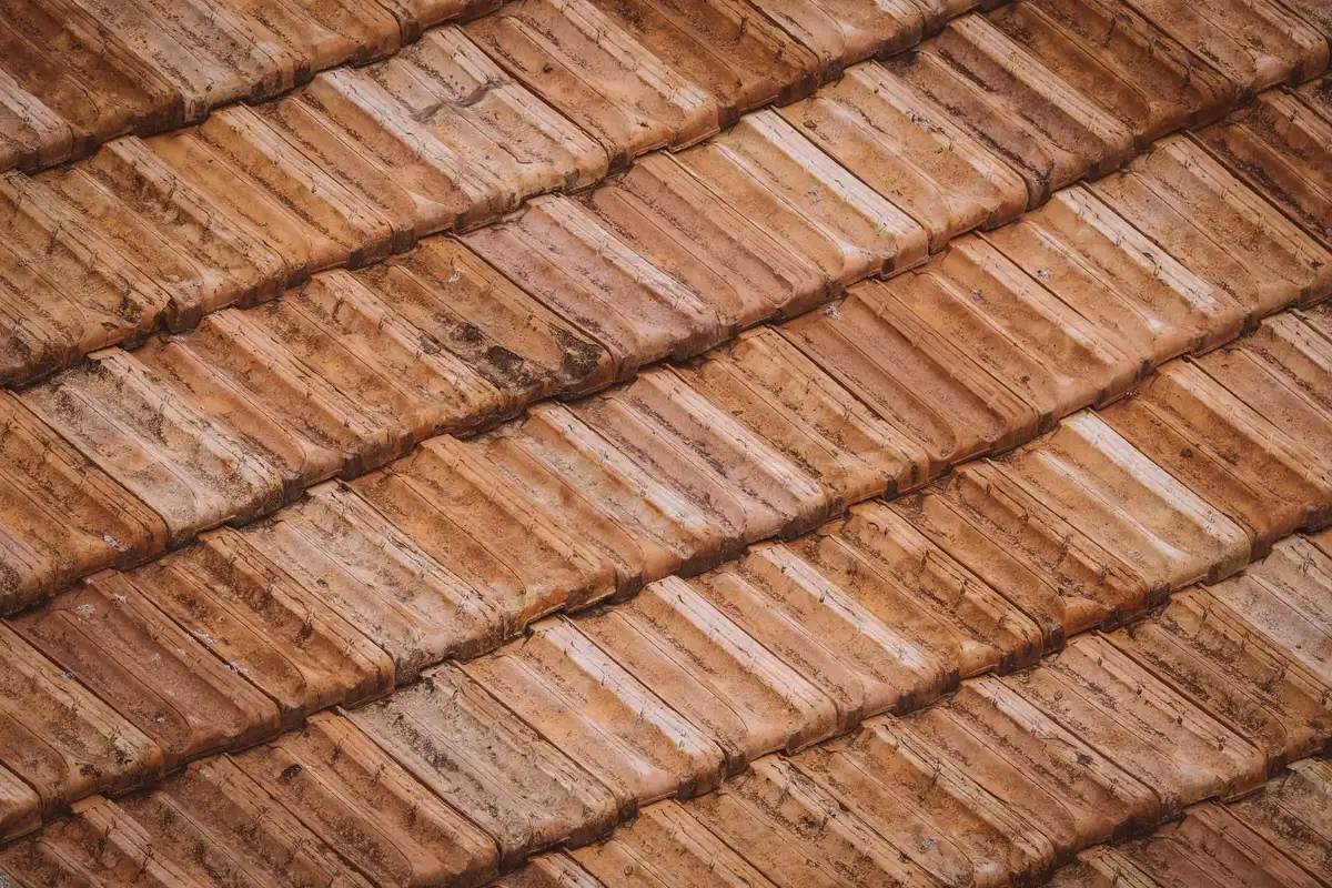Gros plan sur des tuiles en terre cuite montrant la texture naturelle et la teinte chaleureuse du matériau.