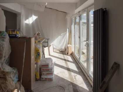 Intérieur spacieux d'une grange en pierre avec poutres apparentes et lumière naturelle