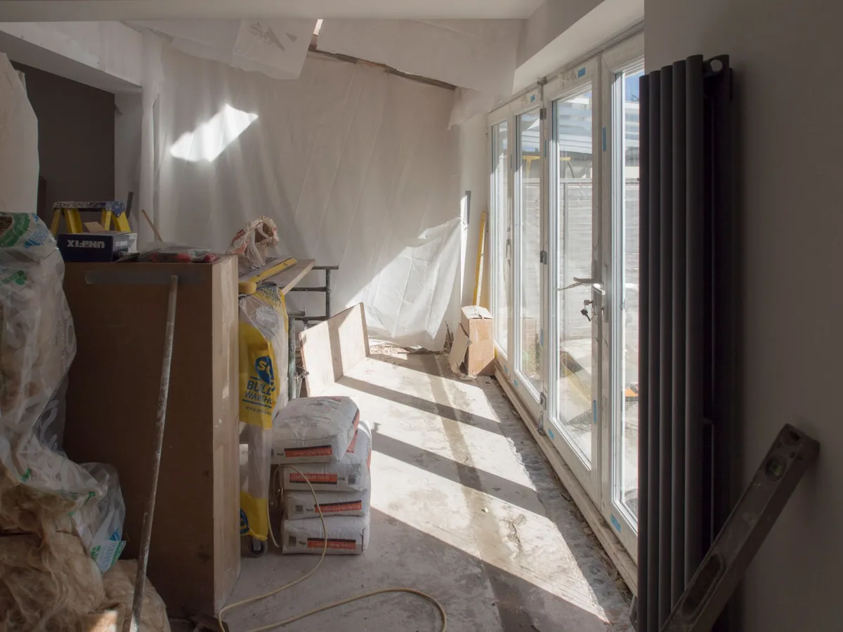 Intérieur spacieux d'une grange en pierre avec poutres apparentes et lumière naturelle