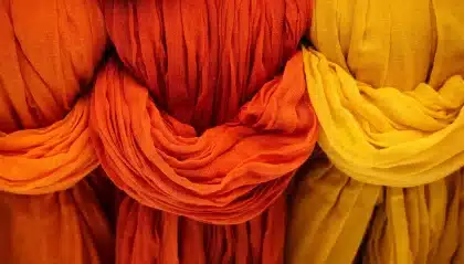 Mains anonymes utilisant une spatule plastique et un chiffon pour nettoyer du carrelage en plein jour