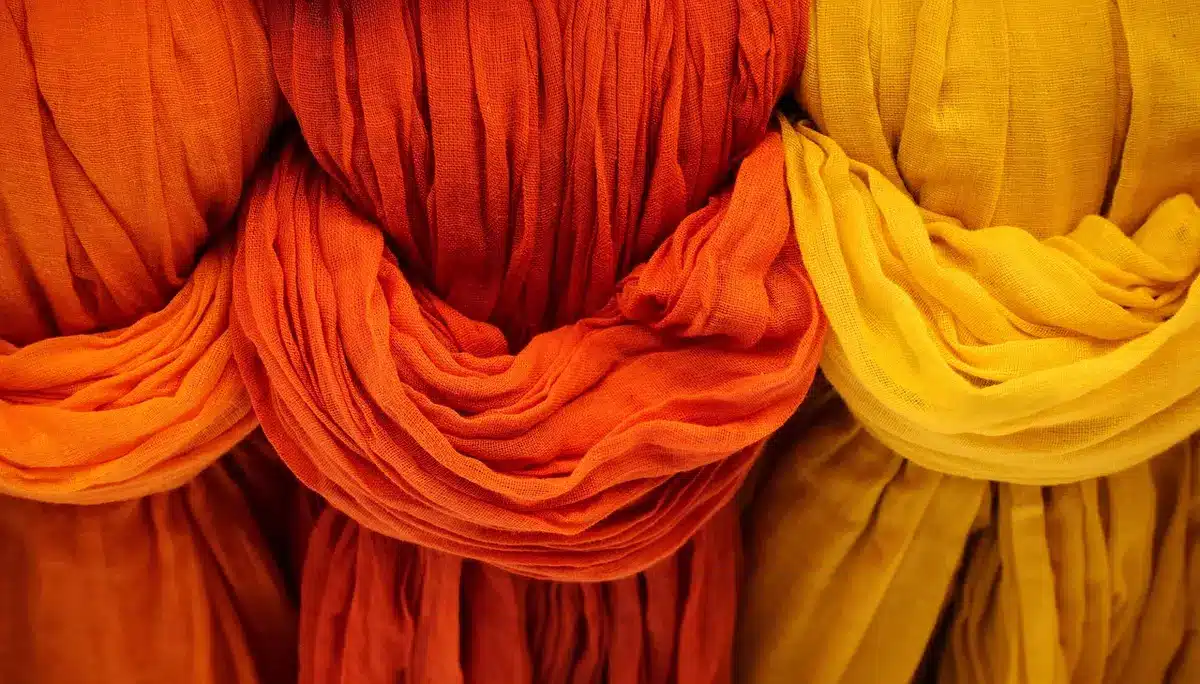 Mains anonymes utilisant une spatule plastique et un chiffon pour nettoyer du carrelage en plein jour