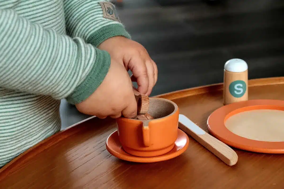 Enfant triant des jouets dans des bacs de rangement colorés