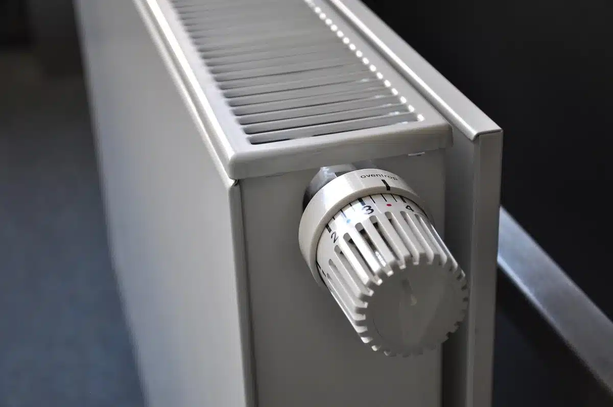 Intérieur lumineux avec radiateur et thermostat montrant des réglages d'économie d'énergie