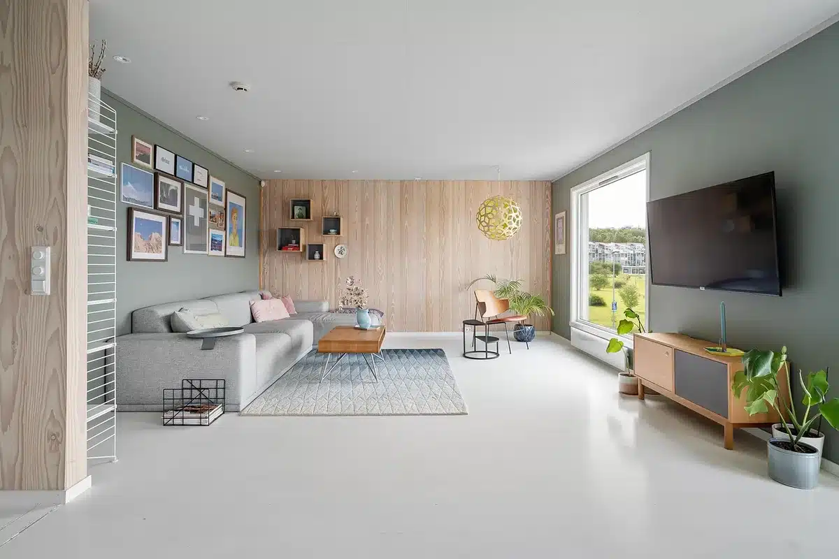 Intérieur béton avec canapé courbe et tapis texturé illustrant le contraste matière