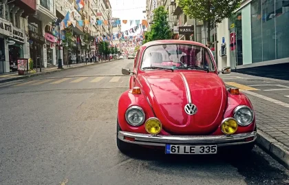 Intérieur d'une voiture électrique avec vue sur une borne de recharge en milieu urbain