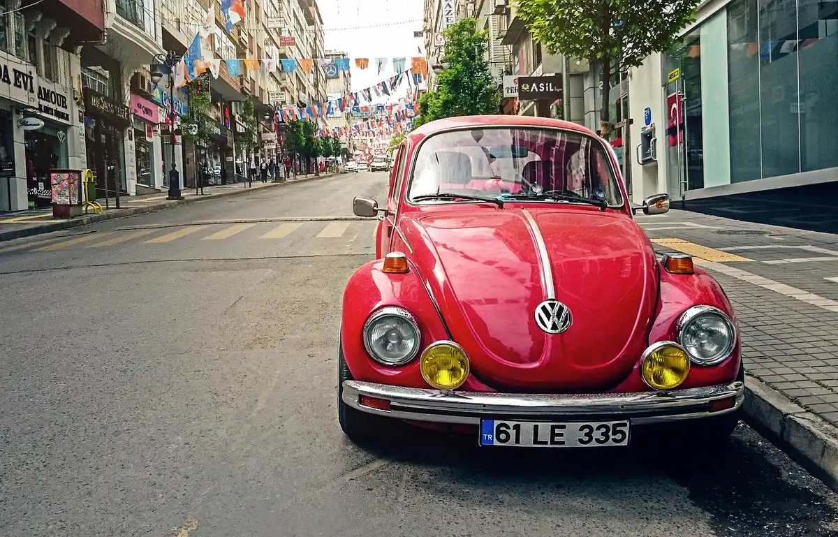 Intérieur d'une voiture électrique avec vue sur une borne de recharge en milieu urbain