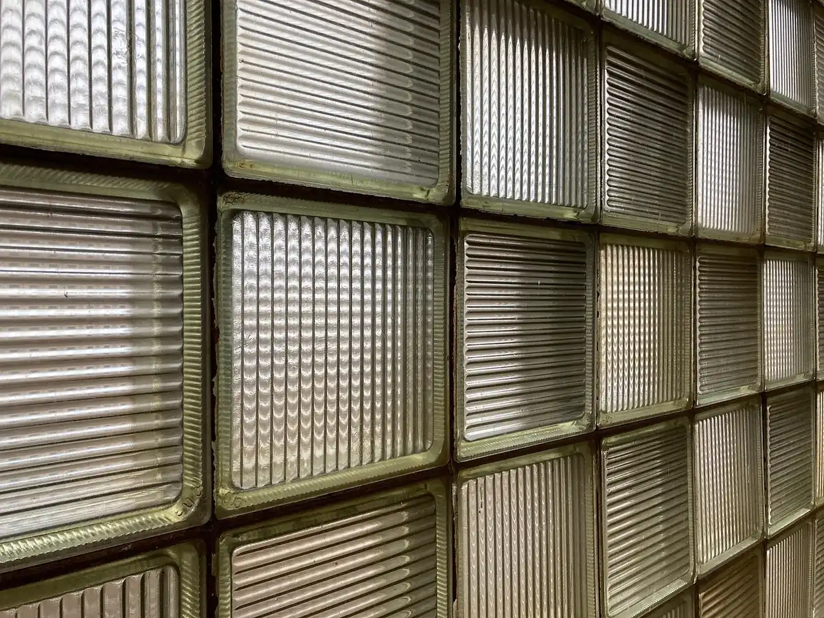 Mur partiel en briques de verre dans une salle de bains baignée de lumière naturelle