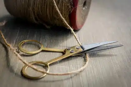 Mains d'un artisan posant un tubage flexible inox dans un conduit de cheminée