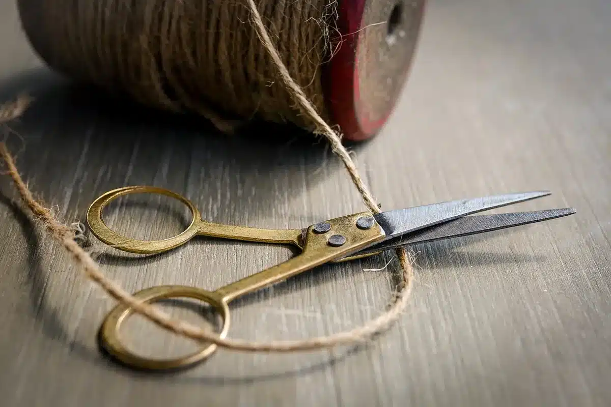 Mains d'un artisan posant un tubage flexible inox dans un conduit de cheminée