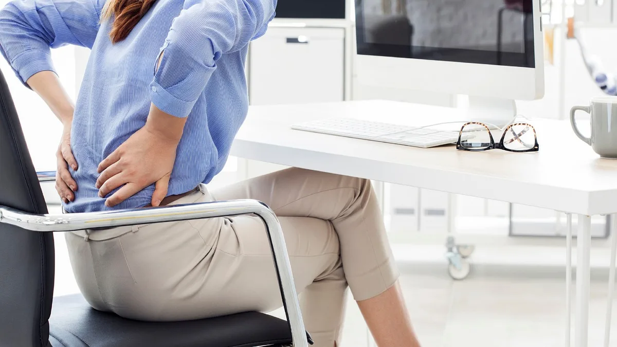 Enfant assis à un bureau avec bonne posture, pieds touchant le sol et avant-bras reposant sur le plateau