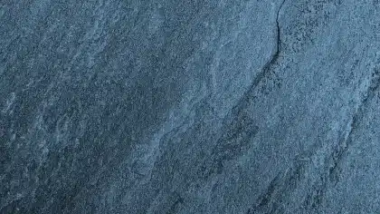 Mains appliquant un mortier de ragréage sur un sol en béton avec une lisseuse